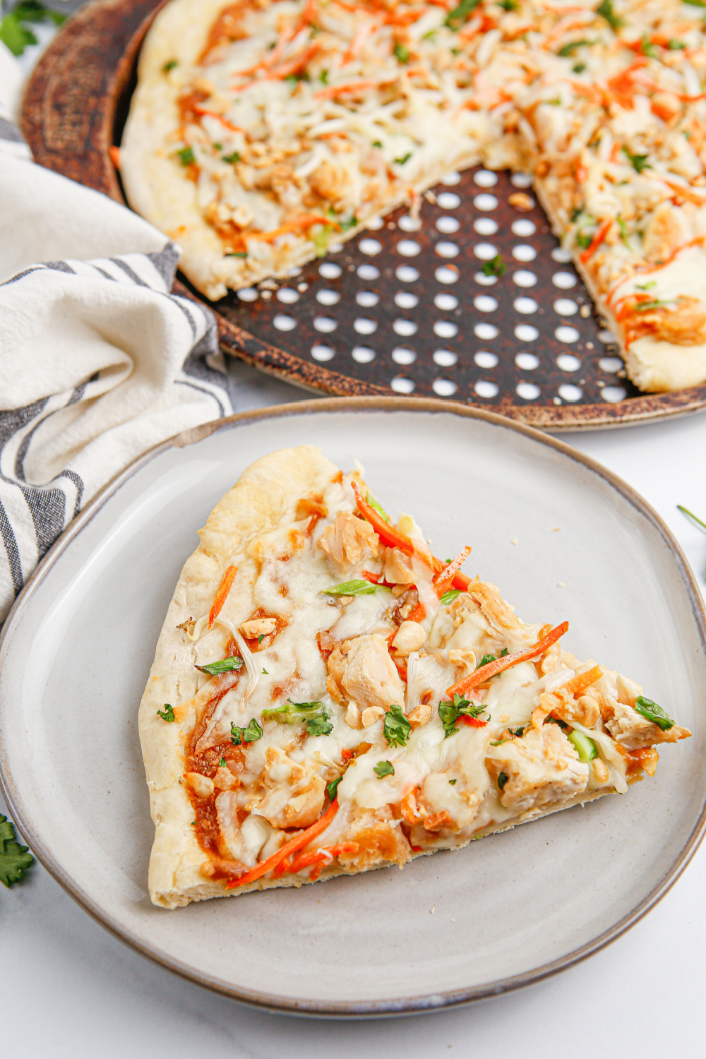 slice of Copycat California Pizza Kitchen Thai Chicken Pizza on a plate