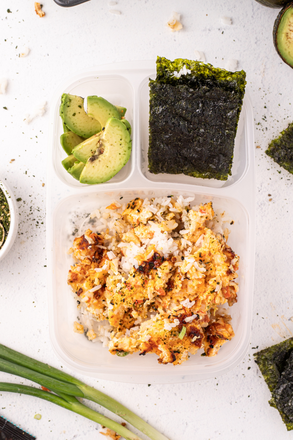 leftover sushi baked packed in a lunch bos with seaweed and avocado
