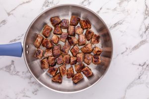 beef bites browned in a pan