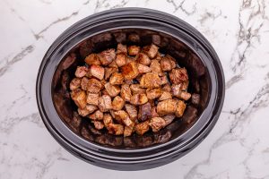 steak pieces added to slow cooker