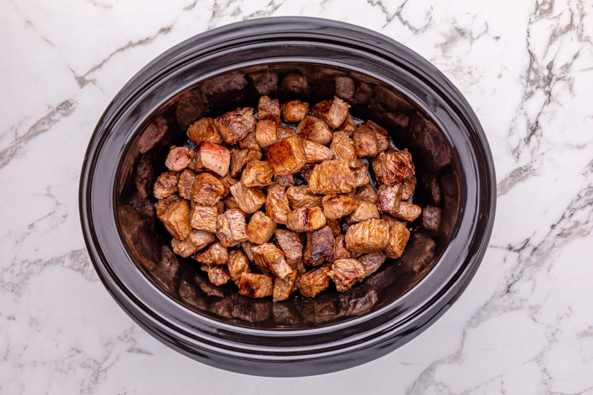 steak pieces added to slow cooker