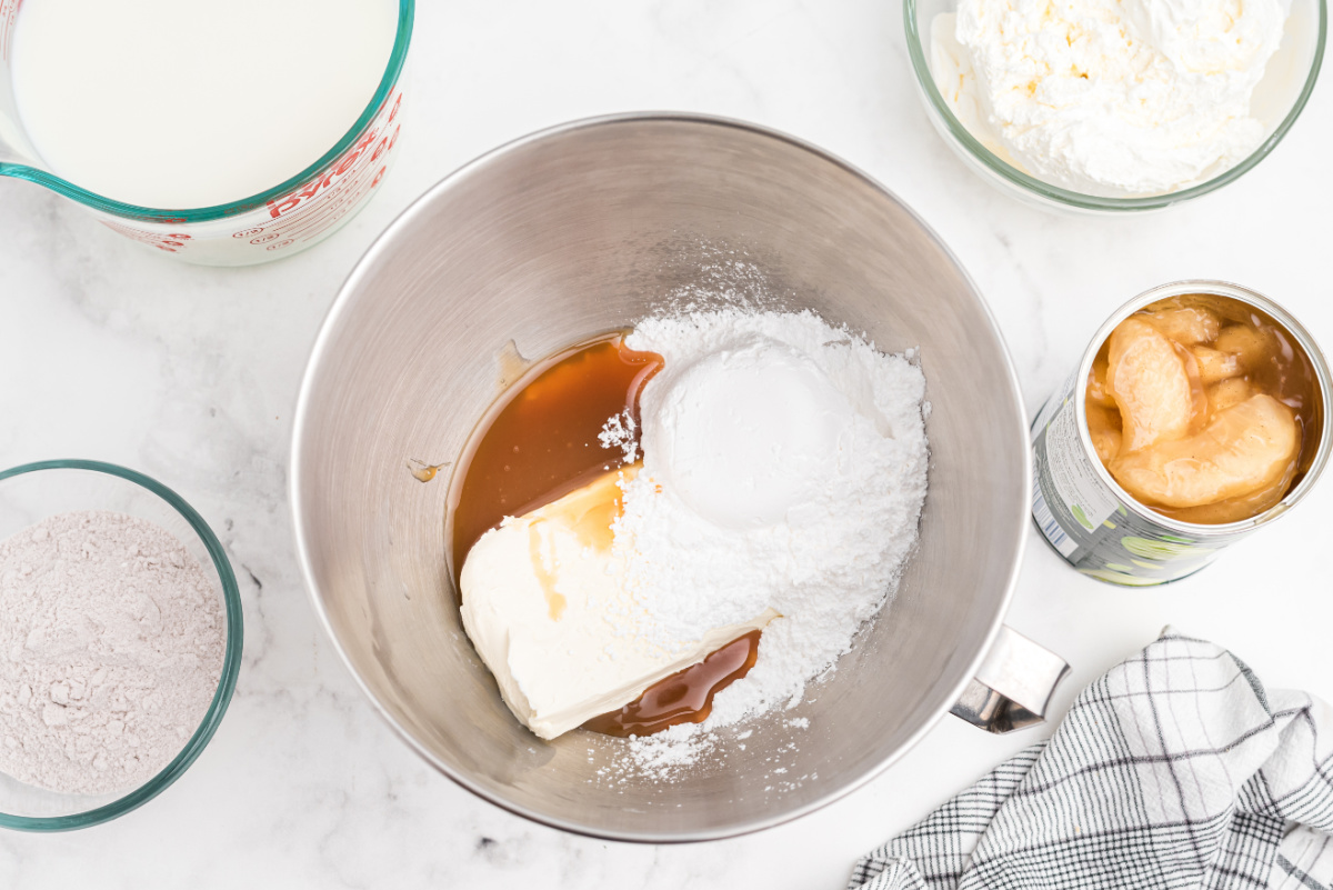 cream cheese, powdered sugar and caramel sauce in mixing bowl
