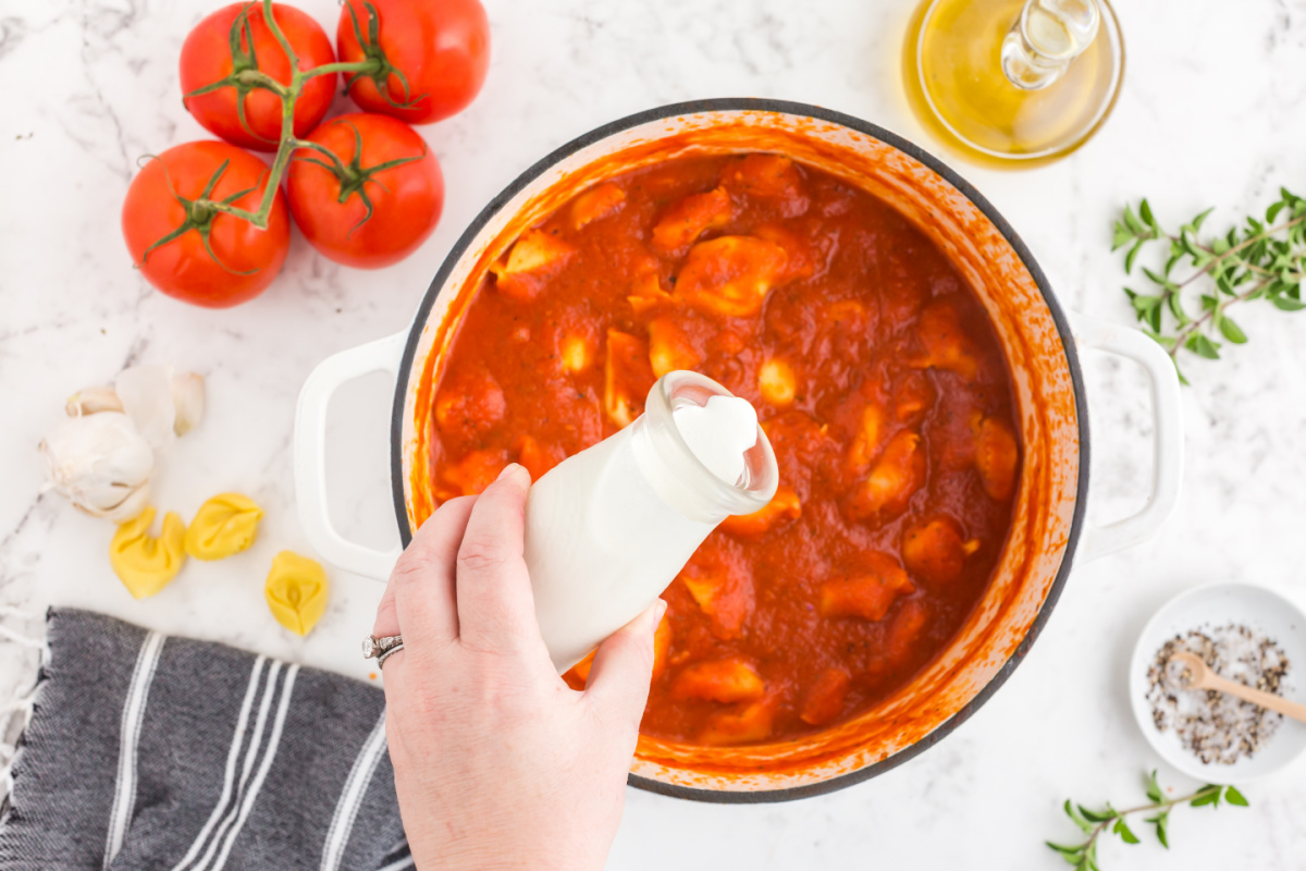 adding cream to the soup pot