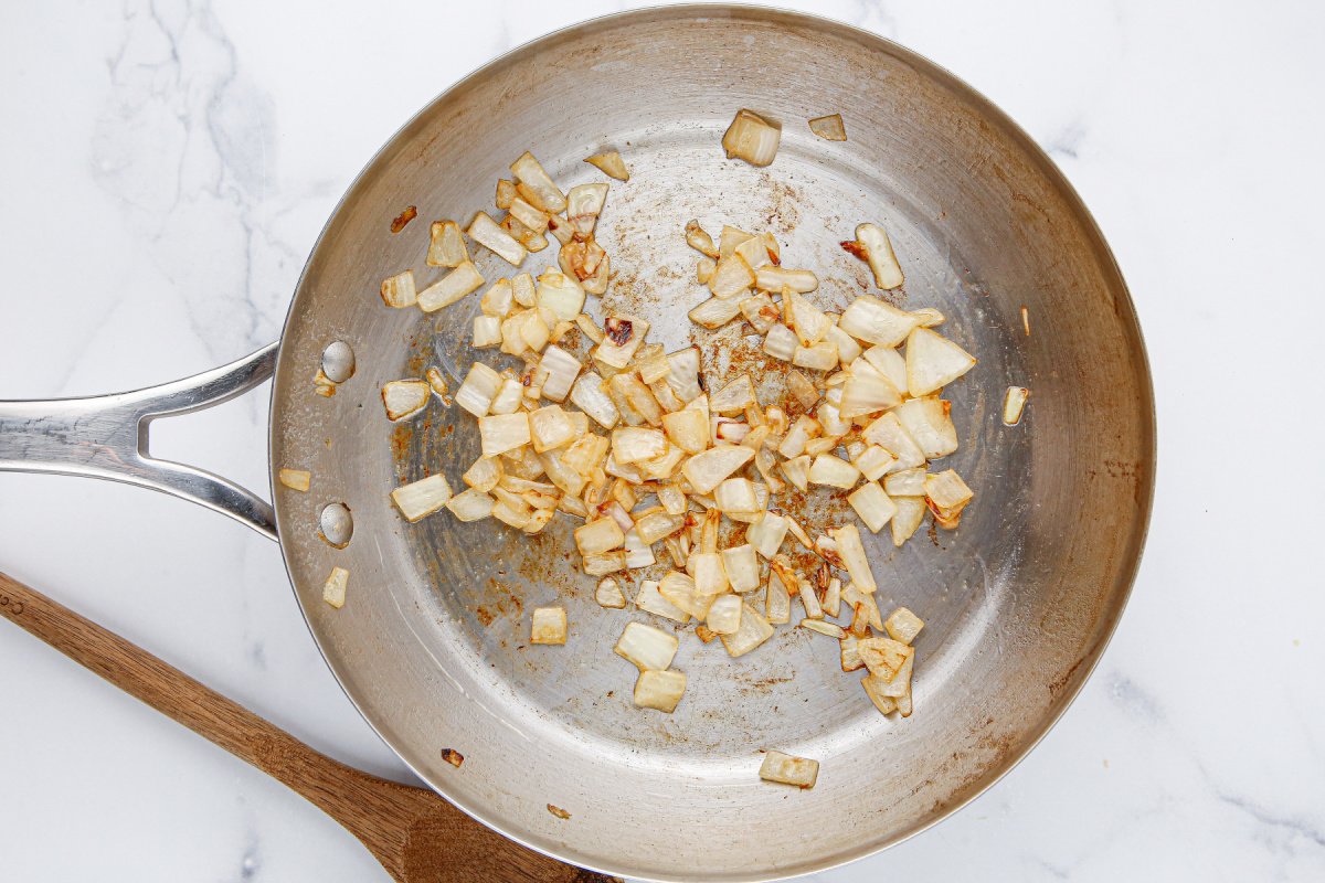 onions being cooked in pan