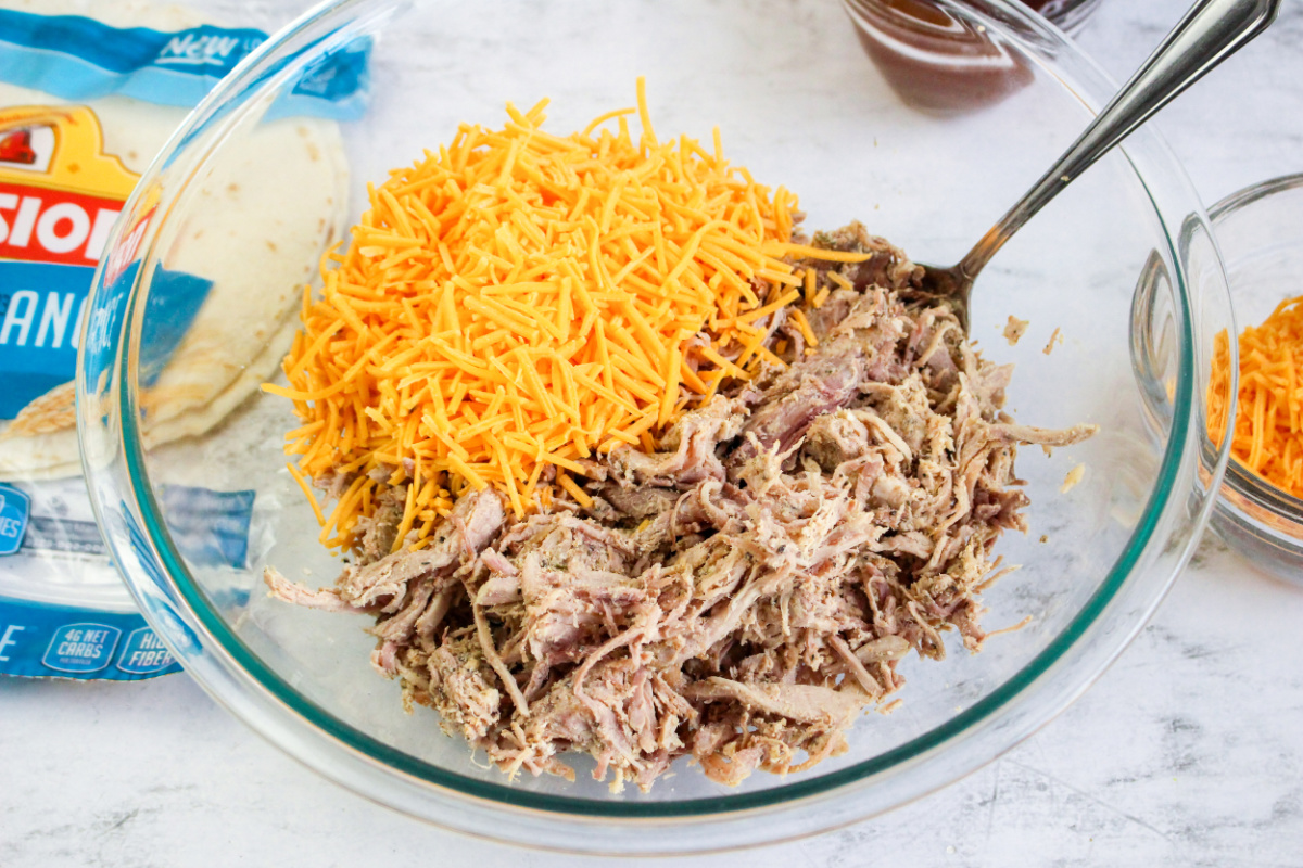 shredded cheese, and pork in a bowl