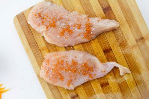 chicken butterflied and seasoned on cutting board