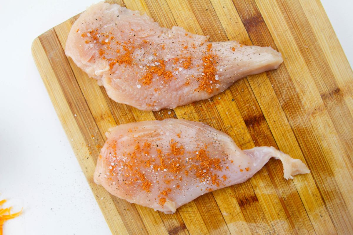 chicken butterflied and seasoned on cutting board