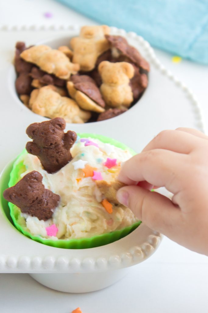 little hand dipping cracker into Copycat Dunkaroo Dip