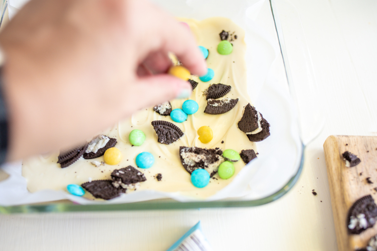 adding candy and cookie pieces to white chocolate