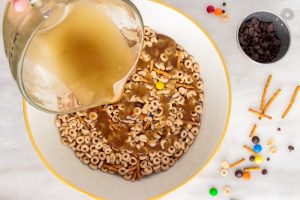 pouring melted butter mixture over cereal mix