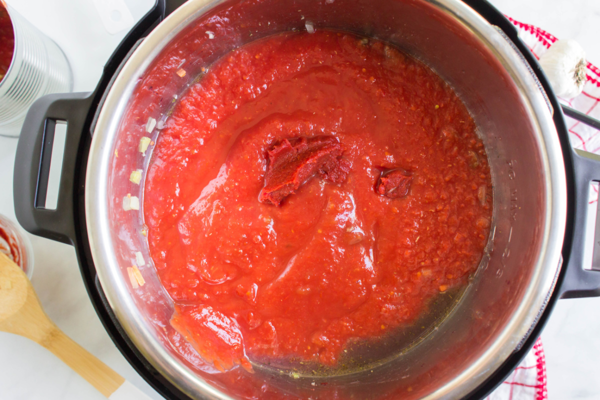 crushed tomatoes and tomato paste added to pot