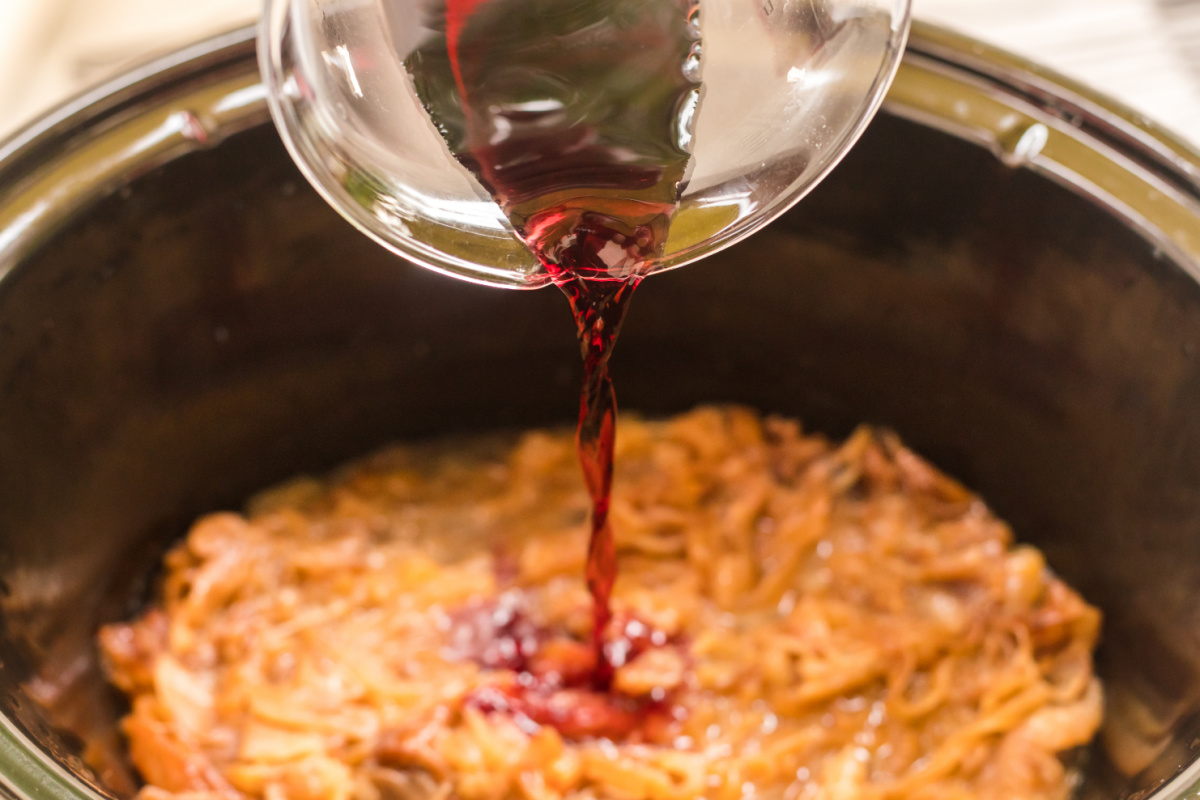 red wine being added to browned onions