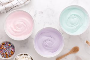 pink, purple and teal colored pudding in 3 different bowls