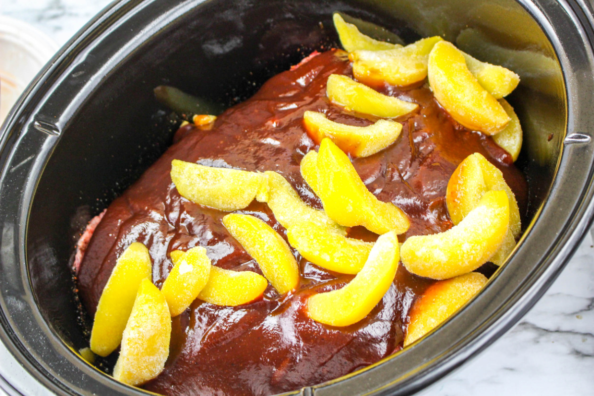 ribs, bbq sauce and peaches in a slow cooker