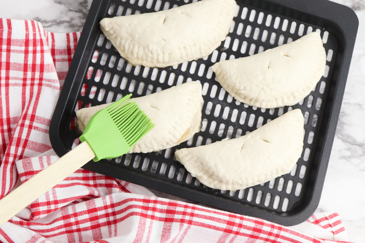 brushing apple pies with butter