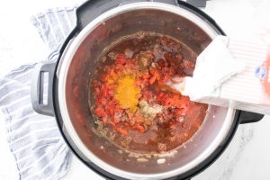 tomatoes, crushed or diced tomatoes, cumin, chili powder, curry powder, and beef broth added to instant pot