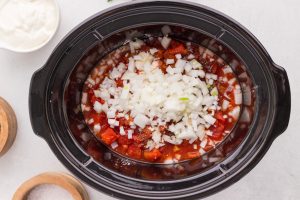 chicken, onion, diced tomatoes, paprika, garlic powder, salt, and pepper in a slow cooker