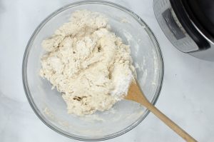dough being mixed with a wooden spoon